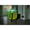 Ryobi grön laserpass med stativinställning inomhus, grön laserlinje synlig mot en oskarp bakgrund av ett rum.