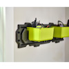 Grön förvaringshylla monterad på vägg med gröna lådor och handverktyg.