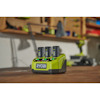 Multiladdare för Ryobi-verktygsbatterier med tre batterier insatta, placerad på en arbetsbänk.