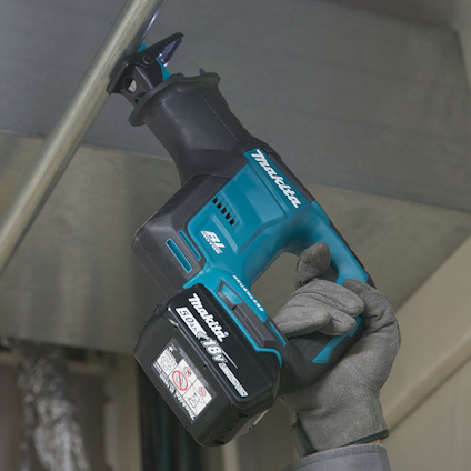En person använder en Makita batteridriven tigersåg för att såga i ett metallrör.