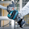 Person använder en Makita kabelsax för att skära ett kabelrör i en industrimiljö.