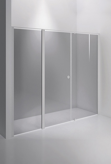 Duschvägg i tre paneler med vitram och tonat glas mot en ljus vägg och golv.