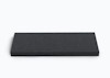 Rektangulär, svart skumplatta med texturerad yta på vit bakgrund.