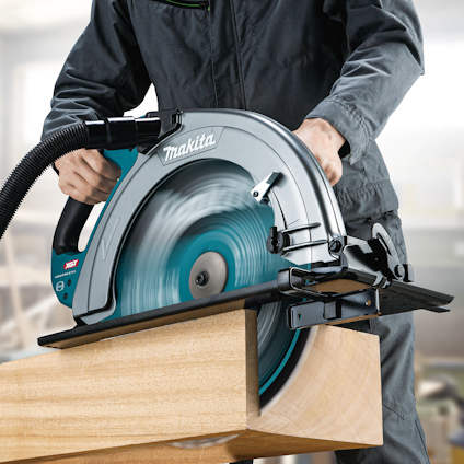 Person i arbetskläder sågar trä med cirkelsåg från Makita.