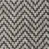 Närbild av textilgolv i grå och beige herringbone-mönster med strukturerad yta.