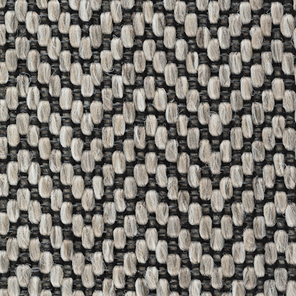 Närbild av textilgolv i grå och beige herringbone-mönster med strukturerad yta.