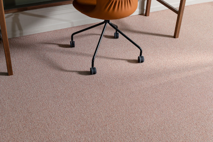 Brunt kontorsstol över beige matta bredvid ett bord med träben.