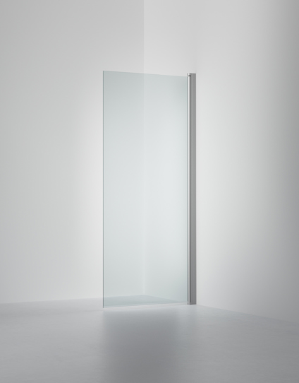 Glasduschvägg med borstad metallprofil, placerad i ett hörn med grå väggar och golv.