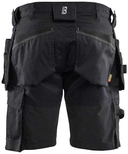 Svarta arbetsshorts med fickor och hällor, sedd bakifrån.