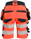 Orange arbetsbyxor med svarta fickor och reflexband, sedda bakifrån.