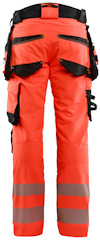 Orange arbetsbyxor med svarta fickor och reflexband runt benen, sedd bakifrån.