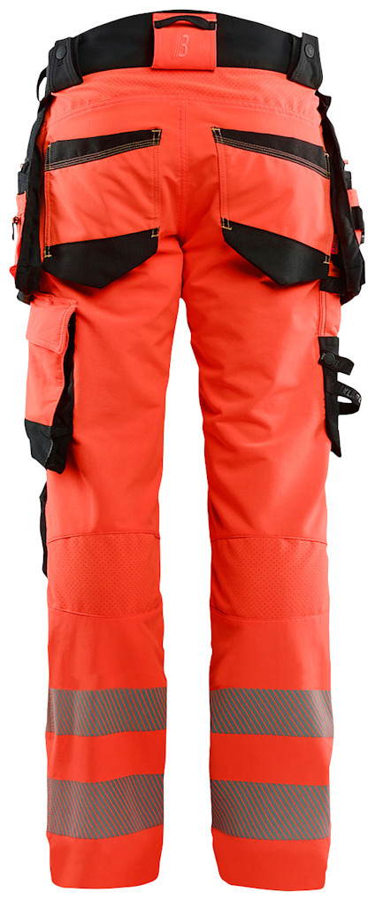 Orange arbetsbyxor med svarta fickor och reflexband runt benen, sedd bakifrån.