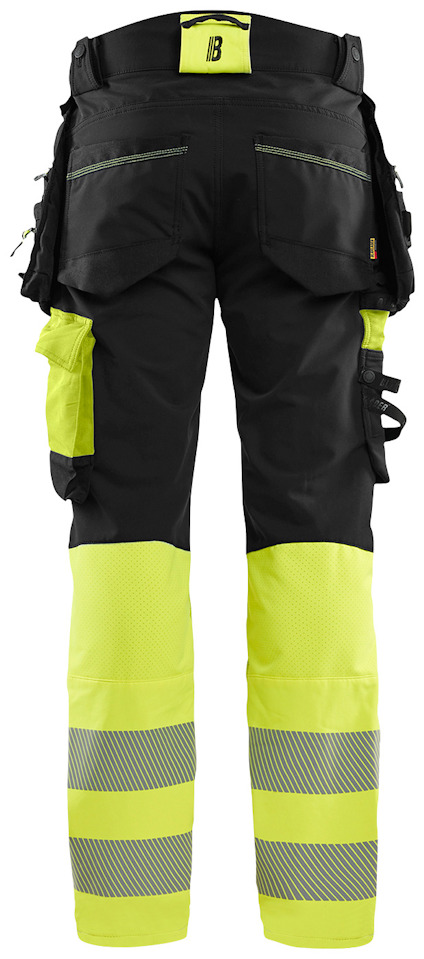Arbetsbyxor med gula och svarta fält, flera fickor och reflexband längst ned på benen.