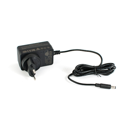 Svart nätadapter med EU-kontakt och kabel med rund DC-kontakt, märkning och symboler synliga.