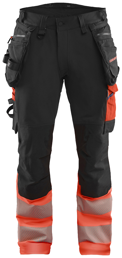 Svarta byxor med röda detaljer, flera fickor och förstärkta knän.