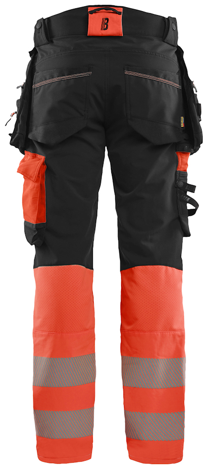 Arbetsbyxa i svart och orange med reflexremsor, fickor och hällor.