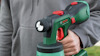 En person håller i en grön Bosch elektrisk sprutpistol.