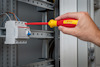 Hand som använder en Bosch-skruvmejsel för att arbeta med en elektrisk panel.