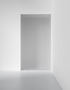 Frostat glasdörr i minimalistisk vit miljö.