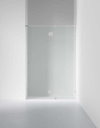 Duschvägg av glas med metallfästen i en minimalistisk, ljus miljö.