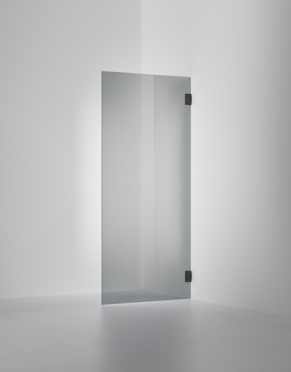 Transparent glasdörr med två svarta gångjärn, placerad mot en vit vägg och vit golvbakgrund.