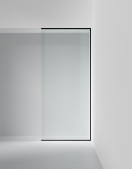 Skjutdörr av frostat glas i en svart metallram installerad i en modern interiör.