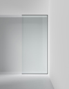 Skjutdörr av glas med en svart ram, installerad i en vit minimalistisk vägg.