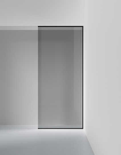 Glasdörr med svart ram monterad i en minimalistisk, vit interiör.