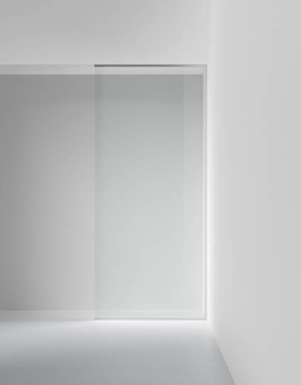 Glastäckad vägg med skjutdörr i minimalistisk, vit interiör.