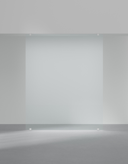 Frostat glasskiva monterad mellan två väggar i ett minimalistiskt rum.