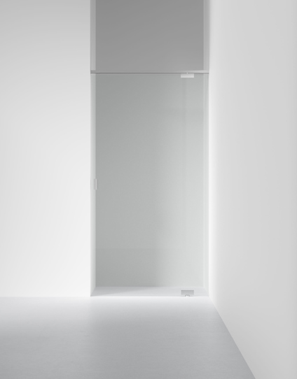 Glasdörr i en vit minimalistisk interiör med ljusa väggar och golv.