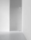 Frostat glasdörr i minimalistisk vit interiör, del av väggen och golvet synliga.