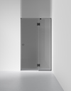 Grå glasvägg med en dörr i minimalistisk design, svart kant och metallgångjärn.