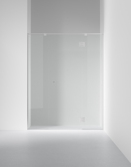 Duschvägg i glas monterad i ett minimalistiskt badrum med grått golv och ljusa väggar.