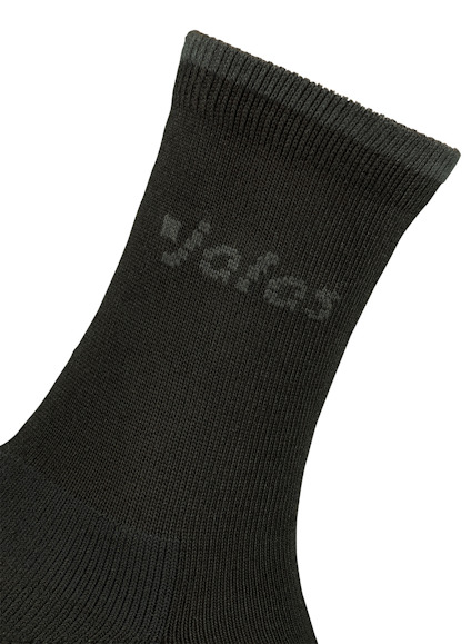 Svart strumpa med vit text som är delvis synlig, står "yafes".