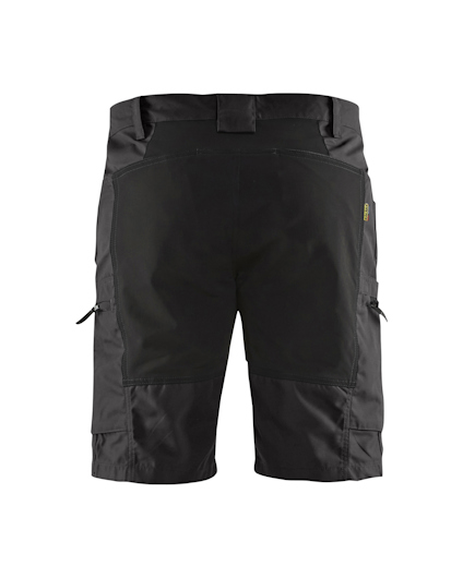 Svarta shorts med flera fickor och förstärkningar, sedd bakifrån.