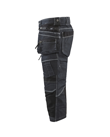 Arbetsbyxa i mörkt tyg med flera fickor och förstärkningar, sett från sidan.