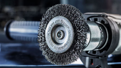 En närbild av en metallborste monterad på ett elverktyg, märkt "BOSCH" och "RPM 4500".