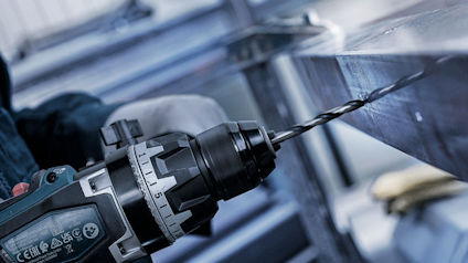 Borrmaskin borrar genom metallstycke.