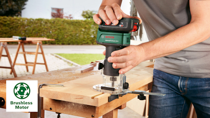 Person använder en Bosch-handrouter på en träbräda utomhus. Symbol för borstlös motor syns.