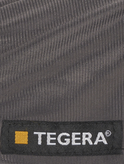 Grått tyg med texten "TEGERA®" i vitt på en svart etikett med gul kvadrat.