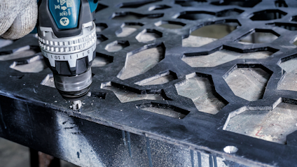 Borr med metallborr används för att bearbeta en detaljerad, geometrisk metallplatta.