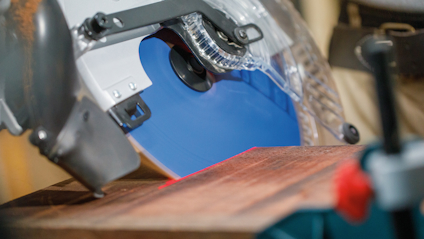 Cirkelsåg med blått blad kapar en träplanka.