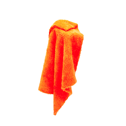 Orange frottéhandduk hängande och veckad.