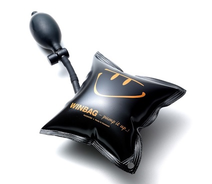 Svart uppblåsbar lyftkudde med orange text "WINBAG pump it up!" och en liten handpump ansluten via en slang.