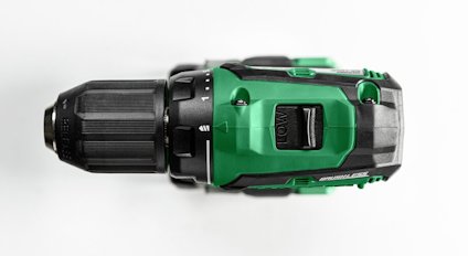 Grön och svart elektrisk borrmaskin sedd från sidan, mot vit bakgrund.