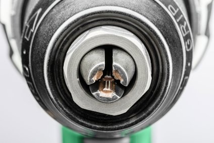 Närbild av en chuck med en insatt mejselbits i metall, detaljerad mekanik synlig runt om.