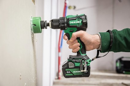 Grön Hikoki borrmaskin används för att borra i gipsvägg.