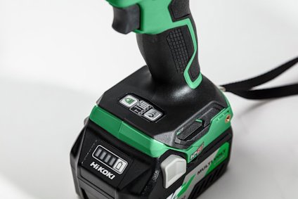Grön och svart sladdlös borrmaskin med varumärket Hikoki och indikatorlampor på batteriet.