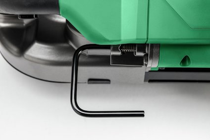 En del av en grön och svart elektrisk apparat med ett utskjutande svart handtag.